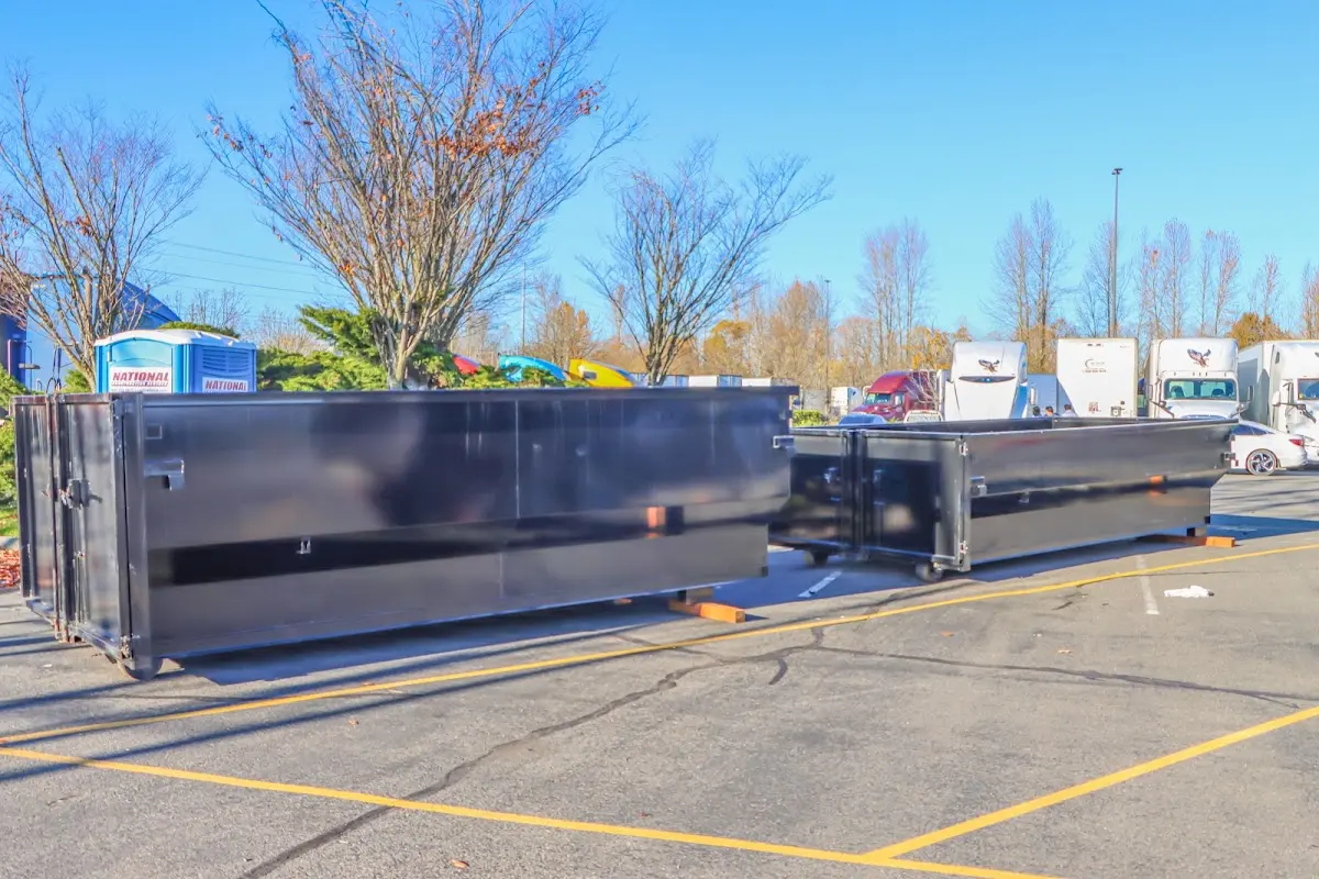 Professional dumpster rental service with roll-off container on residential driveway in Northwood